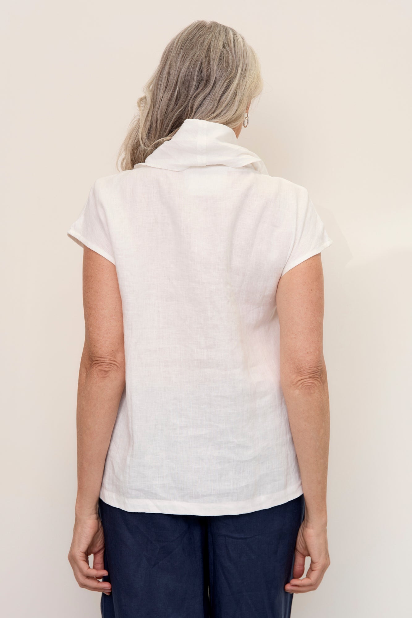 Back of model wearing Hazel Linen Top Warm White with soft fall cowl neck