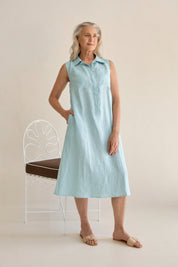Woman wearing the Samara Linen Dress Sea, showcasing the dress's elegant design.