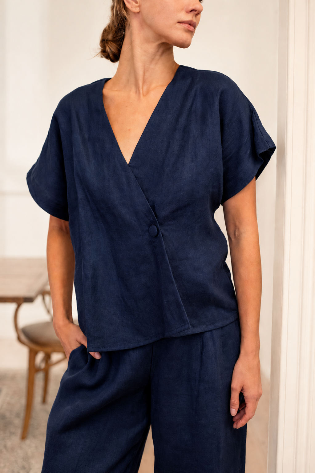 Model wearing a stylish outfit in an airy room featuring Newly Arrived Linen collection.