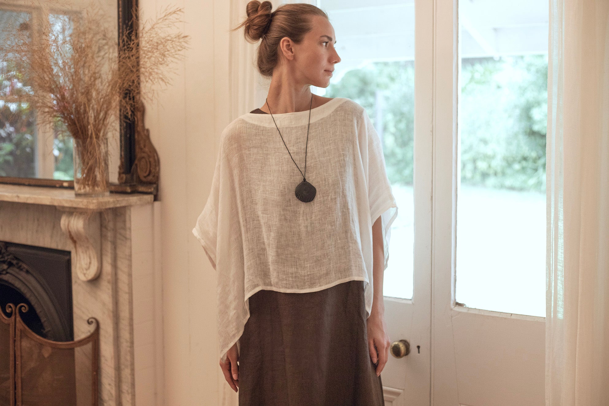 women wearing a long black linen dress with v neck detail, Nelle dress