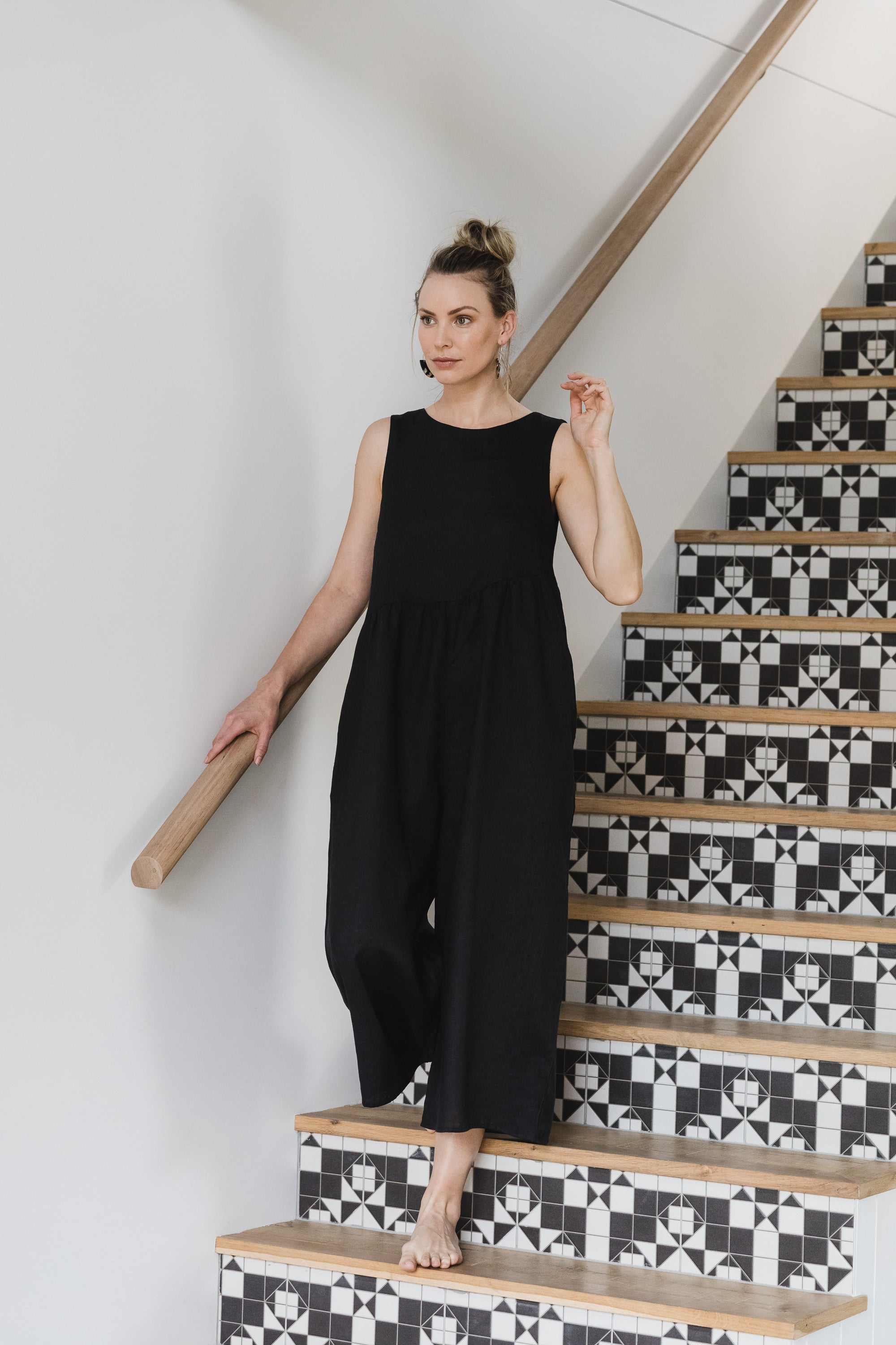 Long black linen jumpsuit worn by women on holiday with thick straps