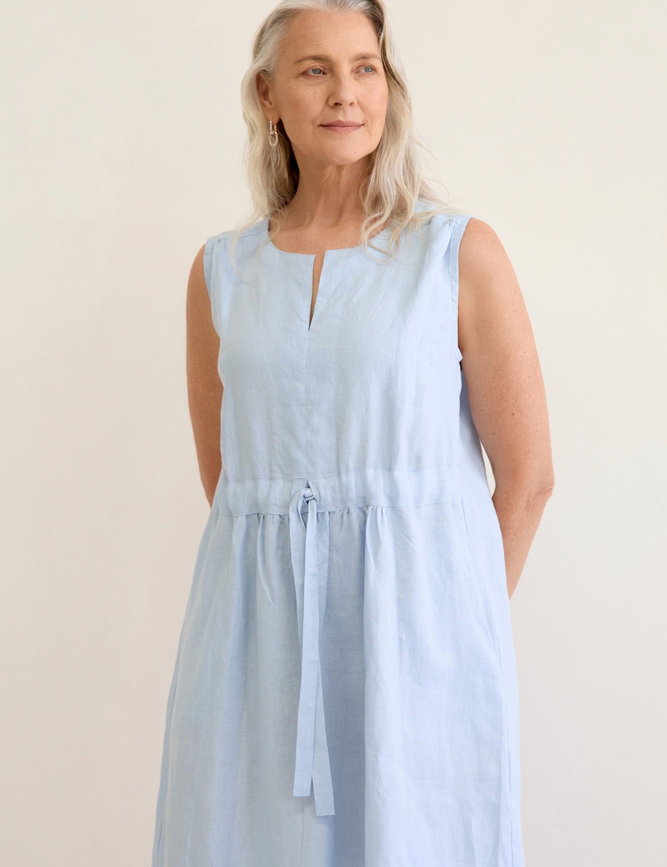 Natural coloured knee length linen dress with sleeves, v neck and waist tie detail