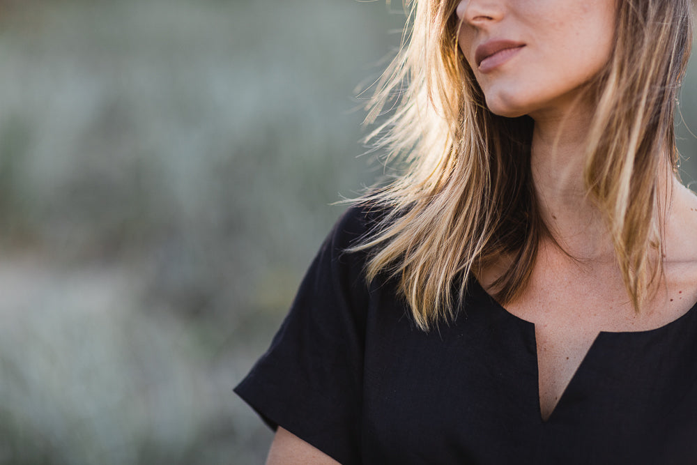 Black linen top worn by women with a v neck detail and short sleeves