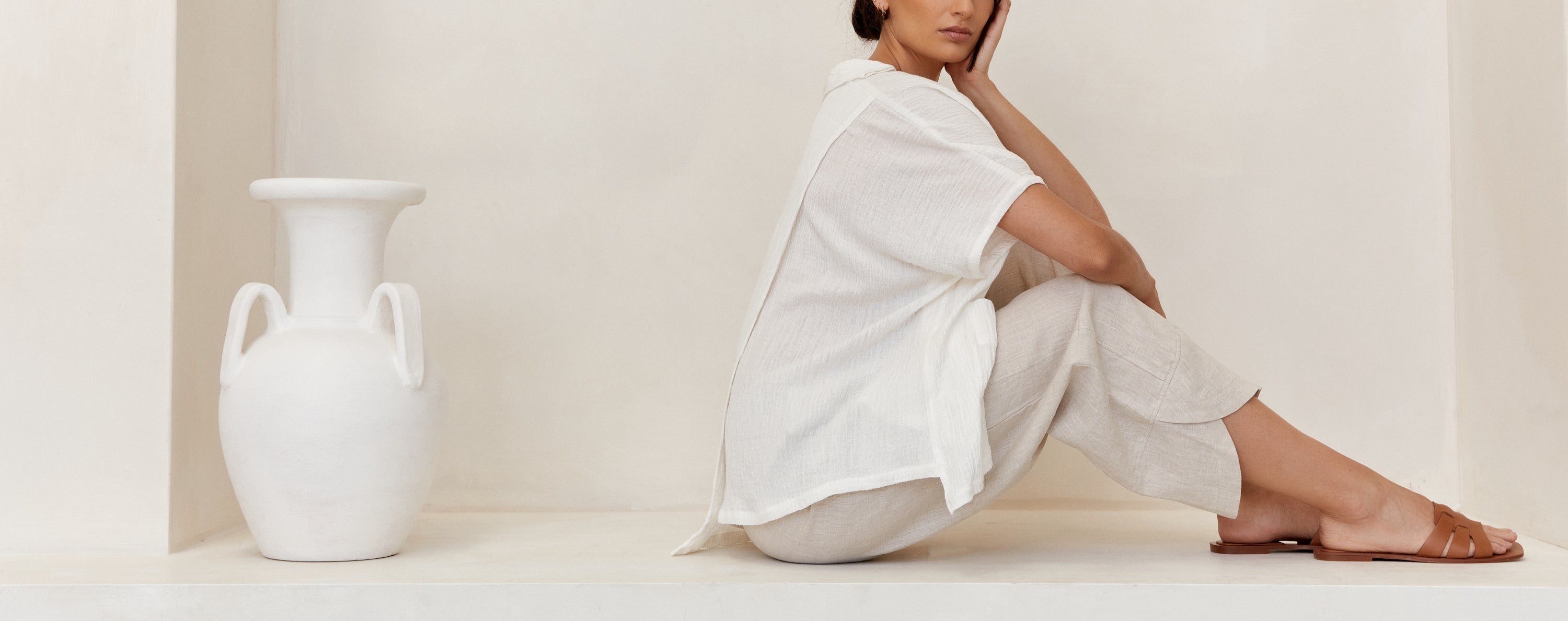 Natural cream coloured linen pants worn by women in casual setting with white linen shirt