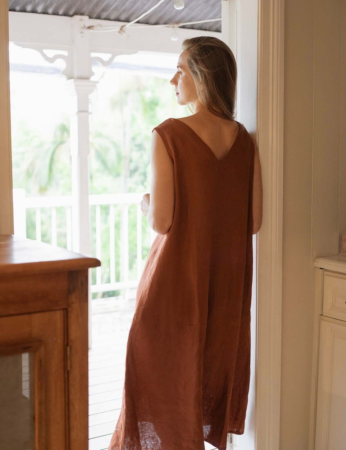 Woman wearing a Cynthia Linen Dress Bark, showcasing its versatile and elegant design.