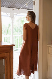 Woman wearing a Cynthia Linen Dress Bark, showcasing its versatile and elegant design.