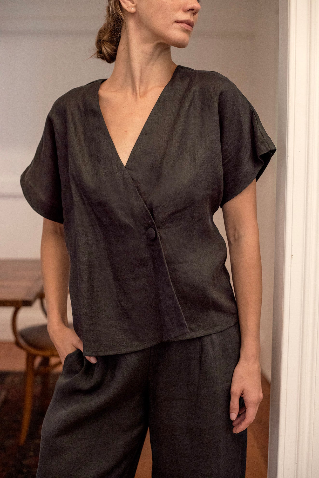 Woman wearing a charcoal linen top and pants in an indoor setting