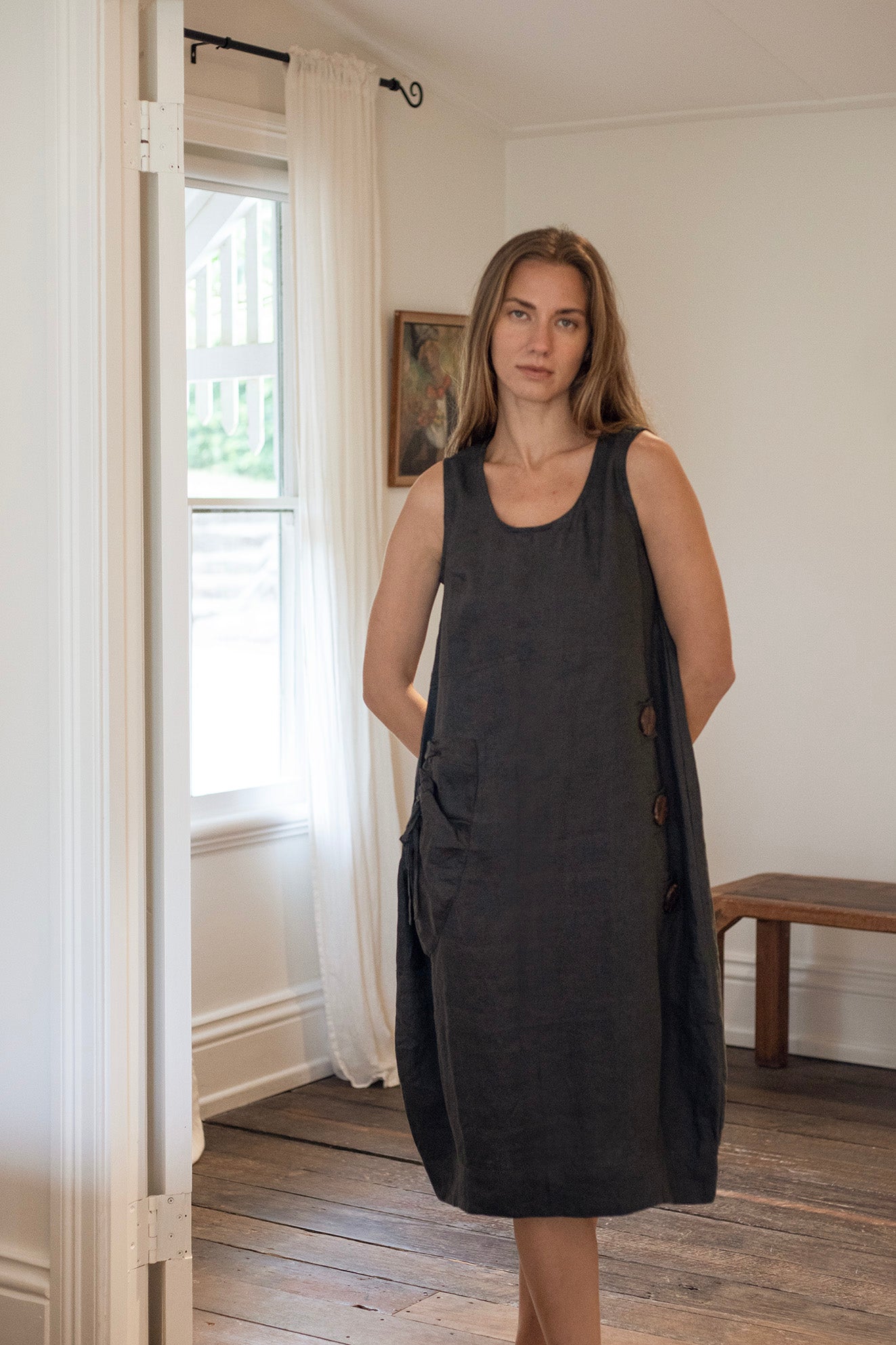 Model wearing the Daisy Linen Dress Charcoal showcasing statement buttons and gathered pocket, perfect for a stylish and comfortable look.