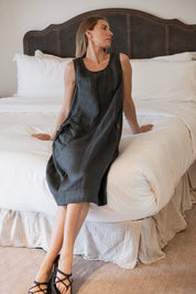 Model wearing the Daisy Linen Dress Charcoal showcasing statement buttons and gathered pocket, perfect for a stylish and comfortable look.
