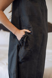 Model wearing the Daisy Linen Dress Charcoal showcasing statement buttons and gathered pocket, perfect for a stylish and comfortable look.