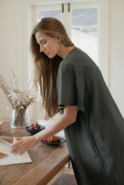Model wearing Charlotte Linen Dress Charcoal, showcasing effortless elegance with a sleeve.