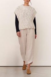 Model wearing the Harper Natural Textured Knit Vest over a long sleeve top, paired with light linen pants and tan shoes.