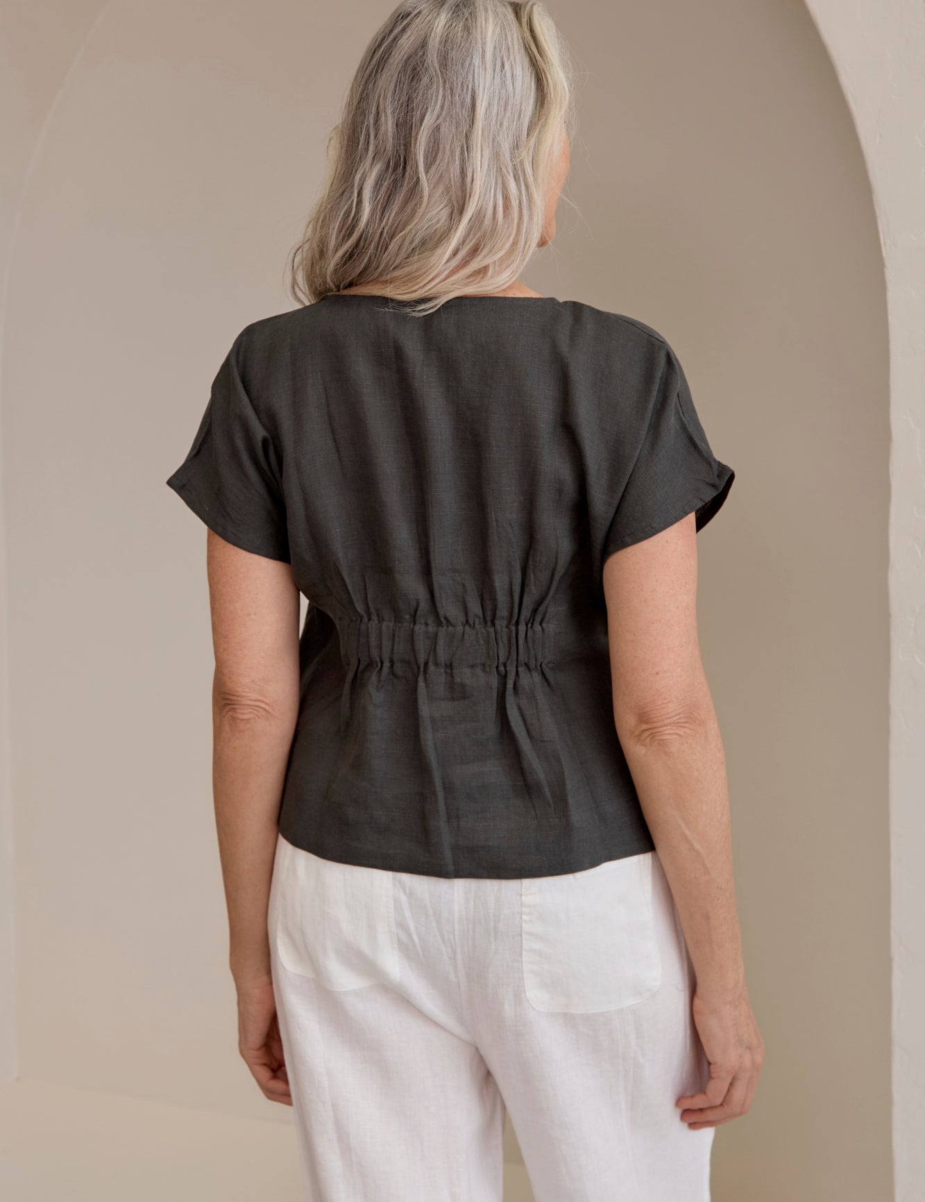 Back of model wearing Zoe Linen Top Charcoal a considered slightly cropped design